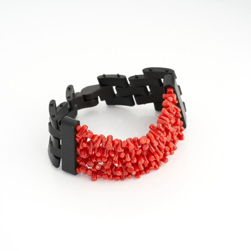  Il Bracciale in Ebano e Corallo Rosso incarna l'essenza della bellezza naturale e dell'eleganza artigianale italiana. Realizzato con Corallo Rosso Naturale del Mediterraneo ed Ebano Pregiato di prima scelta extra. La forma spezzatini del Corallo e il suo colore rosso intenso, conferiscono al bracciale un'aura di mistero e fascino. La chiusura magnetica garantisce comodità e sicurezza, rendendo questo gioiello un simbolo di classe e stile senza tempo.