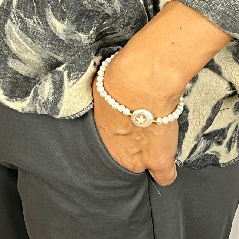 Il Bracciale di Perle con Cammeo è un gioiello unico per una donna moderna. È realizzato interamente a mano e con una circonferenza elastica, è composto da un filo di perle e da un cammeo, inciso a mano, raffigurante una stella. Il Bracciale di Perle con cammeo è prodotto in Italia ed è distribuito da 28dot8™.  Il Bracciale di Perle con Cammeo è completo di certificato di garanzia, che ne garantisce la provenienza della materia prima, la qualità e tante altre informazioni. 